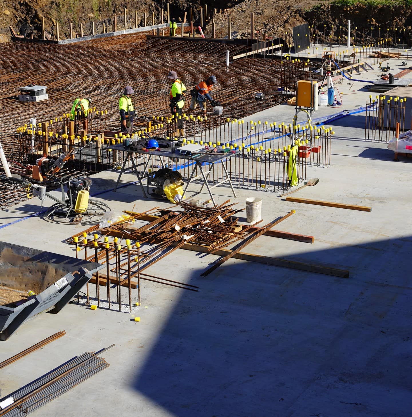 Crews tying steel reinforcement across the slab before the pour