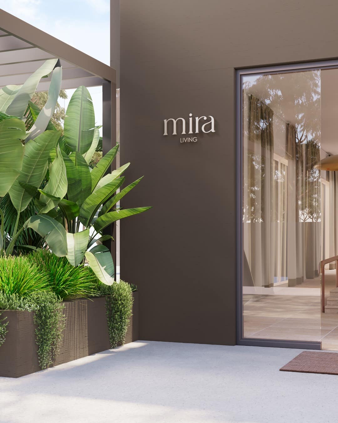The residence entrance — brushed Mira Living signage on a deep bronze wall beside glazed doors and strelitzia planting