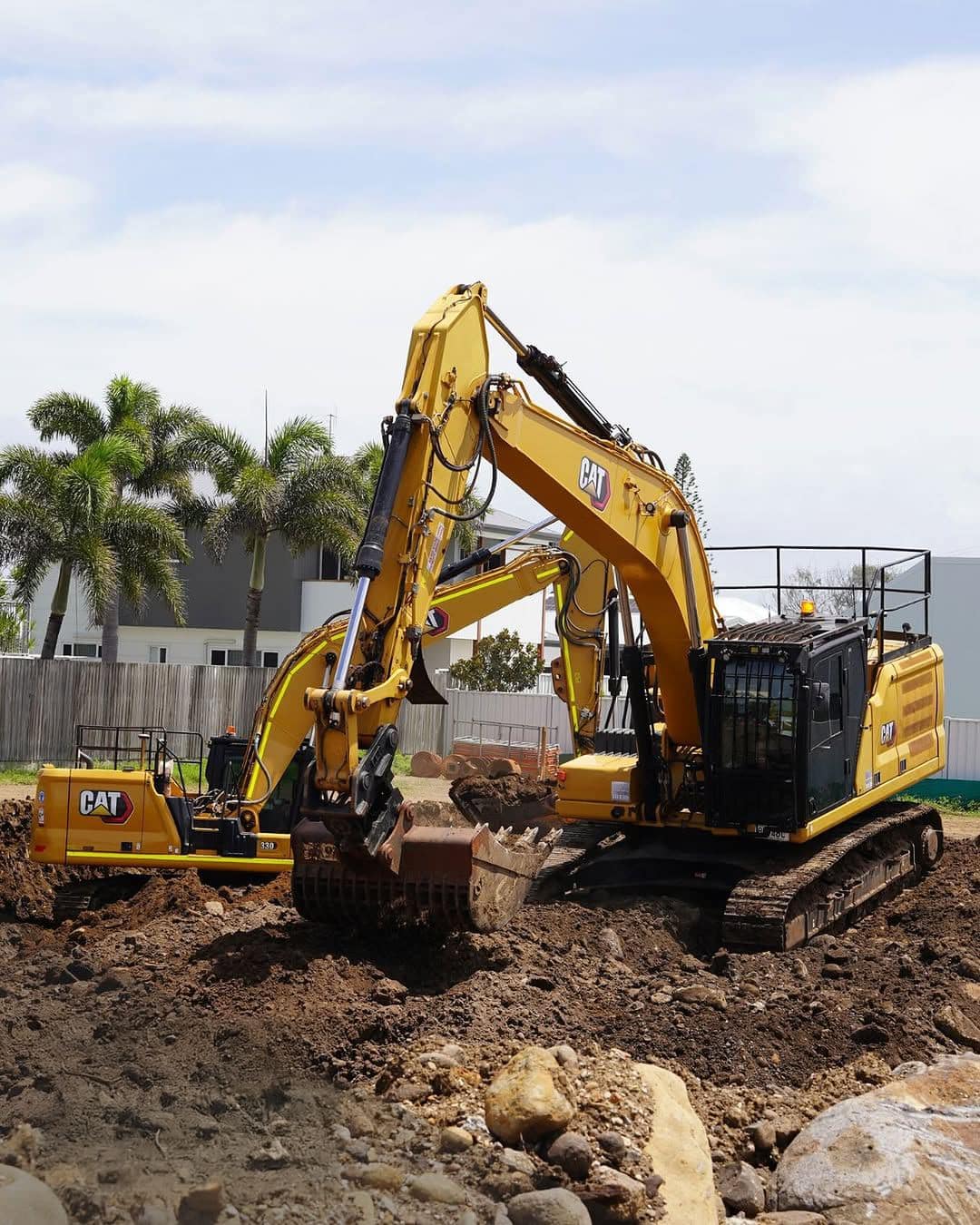 Two excavators working the cleared oceanfront site during early earthworks